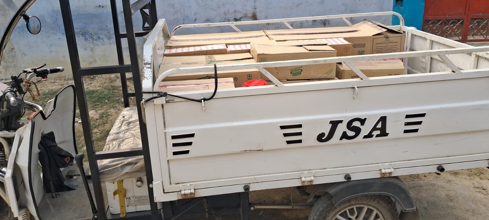 Cargo loader vehicle loaded with sealed cartons of packaged supplies for delivery in Lucknow